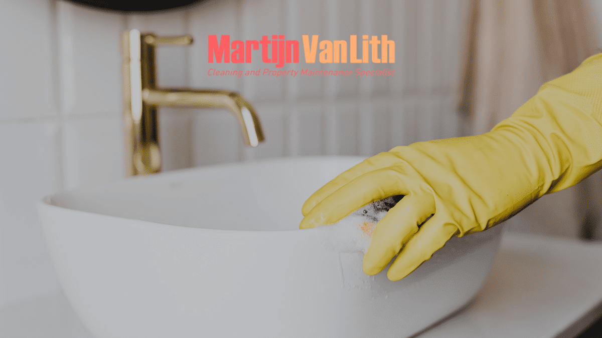gloved hand cleaning the sink